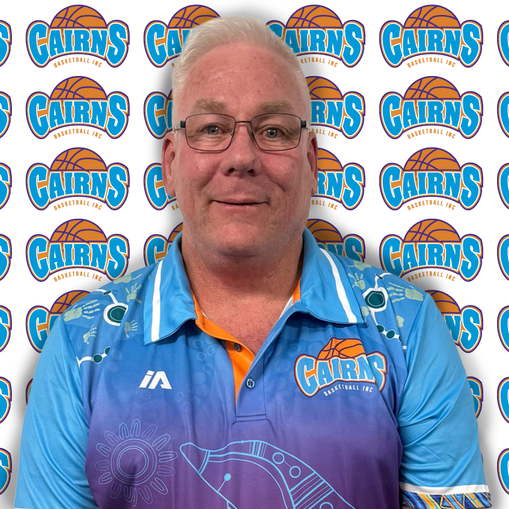 Portrait of a man in a blue Cairns Basketball polo shirt standing in front of a Cairns Basketball backdrop.