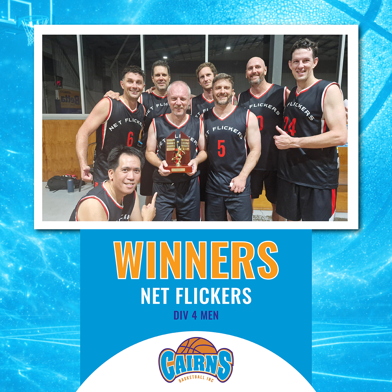 Eight-man basketball team Net Flickers pose with a trophy after winning Div 4 Men in a gym, celebrating their victory.